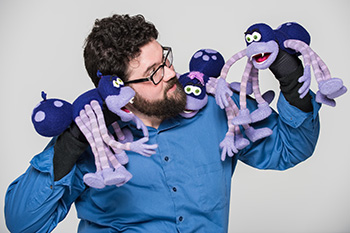 UConn Online Graduate Certificate Graduate and Student Brandon Kirkham shares his story while holding many puppets and performing.